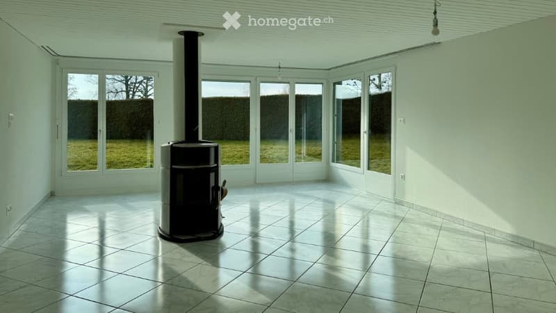 white walls, white tiles, fireplace, sliding doors, view of green grass and hedge