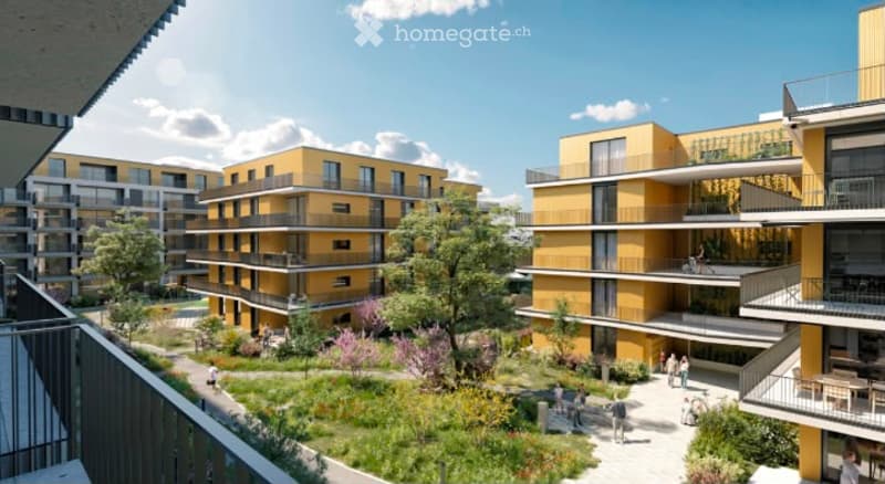 Modern multi-story residential building complex with yellow facades, balconies, and a landscaped courtyard area with trees and pathways.