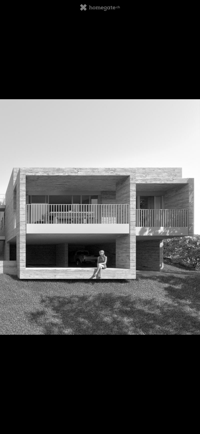 Modern two-story house with a raised ground floor, featuring large windows, balconies, and a covered parking area.