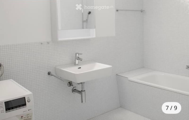 white tiles, white bathtub, white sink, built-in shower, washing machine, mirror
