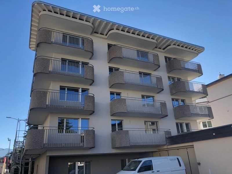 modern apartment building, balconies, multiple floors, white exterior, large windows