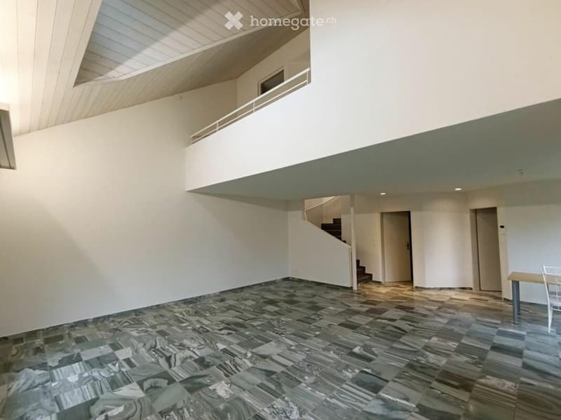 Empty room with marble flooring, white walls, and a staircase leading to an upper level. No furniture or equipment is present.