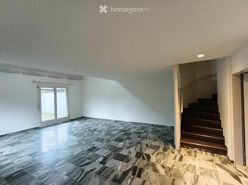 Empty room with marble flooring, white walls, and a staircase leading upwards. Features a large window with blinds and recessed ceiling lighting.