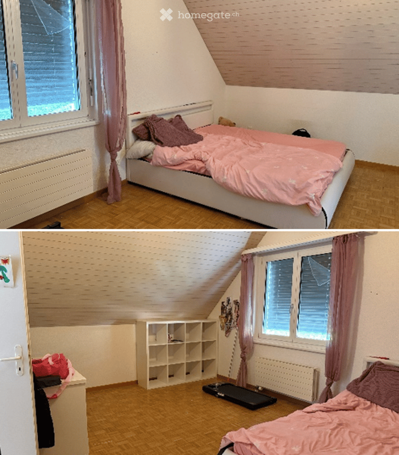 Cozy attic bedroom with wooden flooring, slanted ceiling, large window with pink curtains, bed with pink bedding, shelf unit, laptop, and handbag.