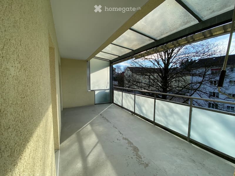 Balcony with glass railings, covered area with glass ceiling, no furniture