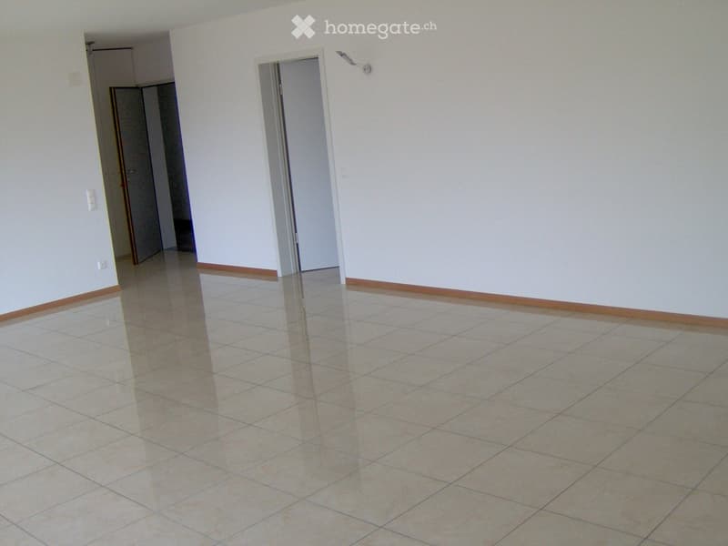 Empty room with tiled floor and white walls, featuring two open doorways leading to adjacent spaces.