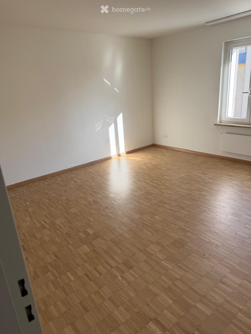 Unfurnished Room. Empty room with wooden flooring and white walls, featuring a window with a radiator below it.