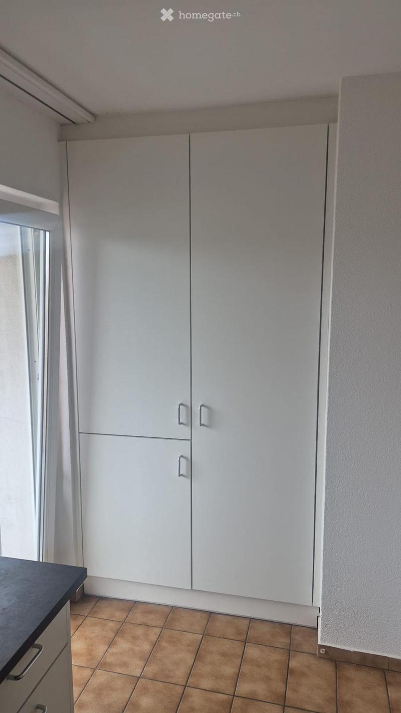 Unfurnished Room. Empty room with white built-in cabinets, tiled floor, and a window on the left side.
