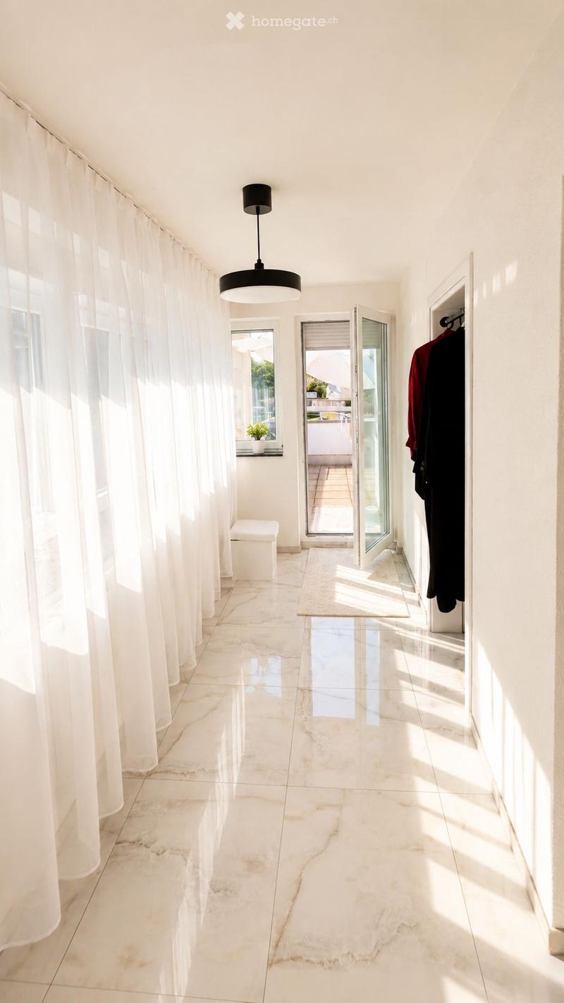 Bright, minimalist hallway with white marble flooring, large white curtains, a modern pendant light fixture, and an open doorway leading to a balcony area.