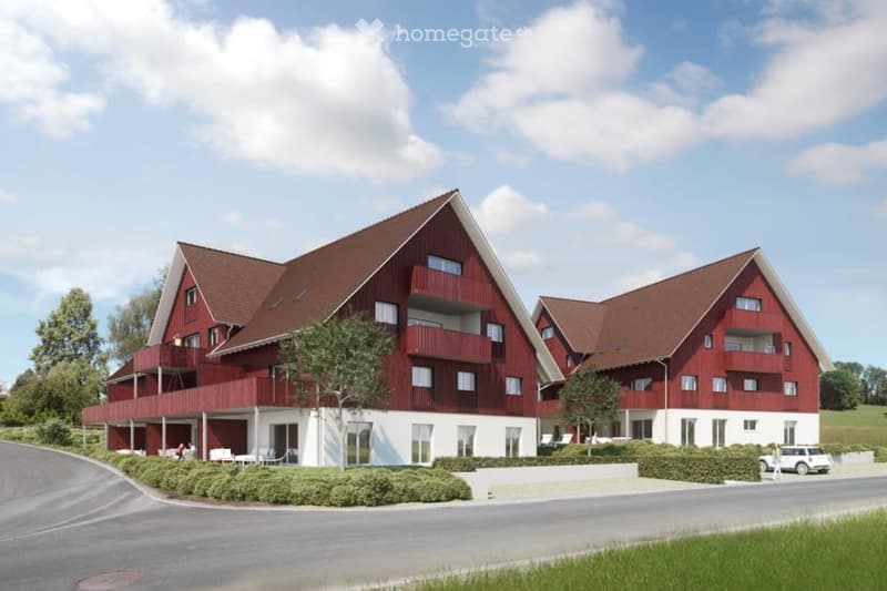 Two-story residential building with red wooden facade, white trim, multiple balconies, and a sloped roof.