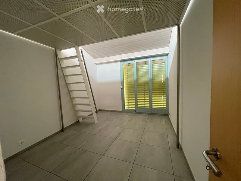 Empty hallway with tiled floor, white walls, and a staircase leading upwards. Features a glass door with blinds and a modern ceiling light fixture.