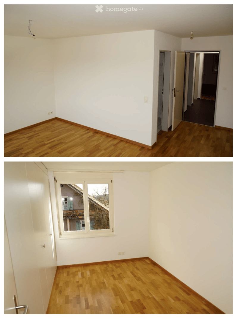 Two empty rooms with wooden flooring and white walls. The first room has a wooden floor and white walls, with a doorway leading to another room. The second room has a large window with a view of a building and a tree, and a wooden floor.