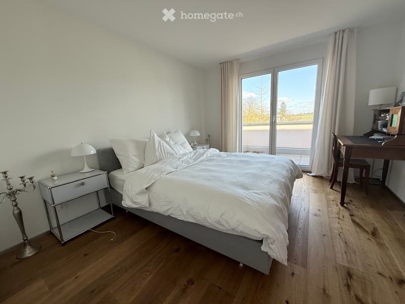 Bedroom with bed, nightstands, lamps, desk, chair, sliding glass door, wooden floor, white walls, view of the outside