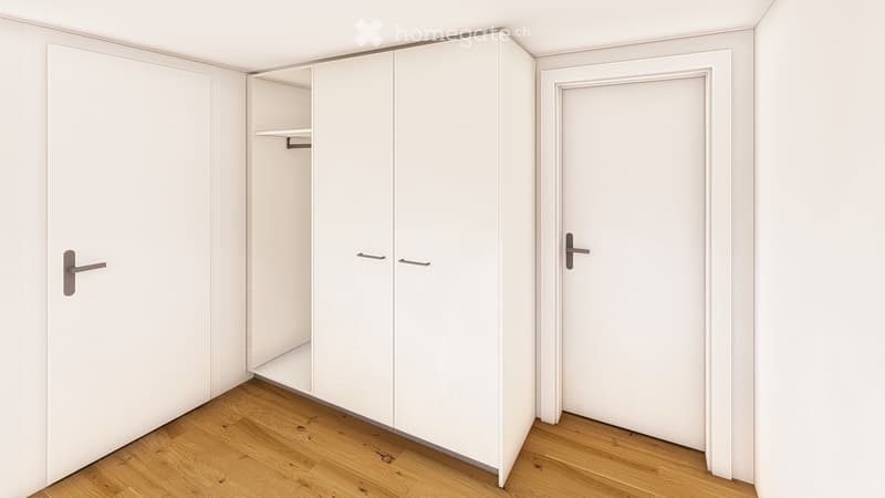 Empty room with white walls, wooden floor, built-in closet with shelves, and a closed door.