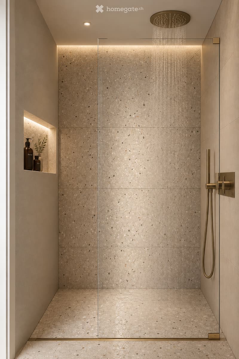 Modern shower area with a glass enclosure, marble tiles, and a rainfall showerhead. Includes a small shelf with a bottle and plant.