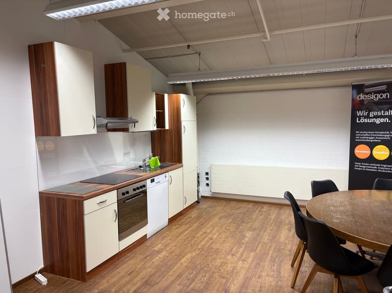 Modern kitchen with white and wood cabinets, stainless steel appliances, and a small dining area with a table and chairs.