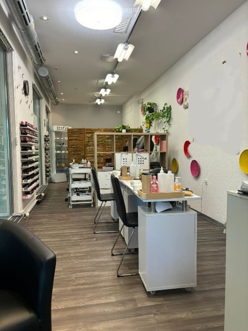 beauty salon, wooden floor, black chairs, white desks, shelves with bottles, white walls, ceiling lamps, glass door