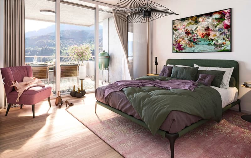 Modern bedroom with a large bed, green bedding, a pink armchair, a nightstand, a large window with a scenic mountain view, and a decorative painting on the wall.