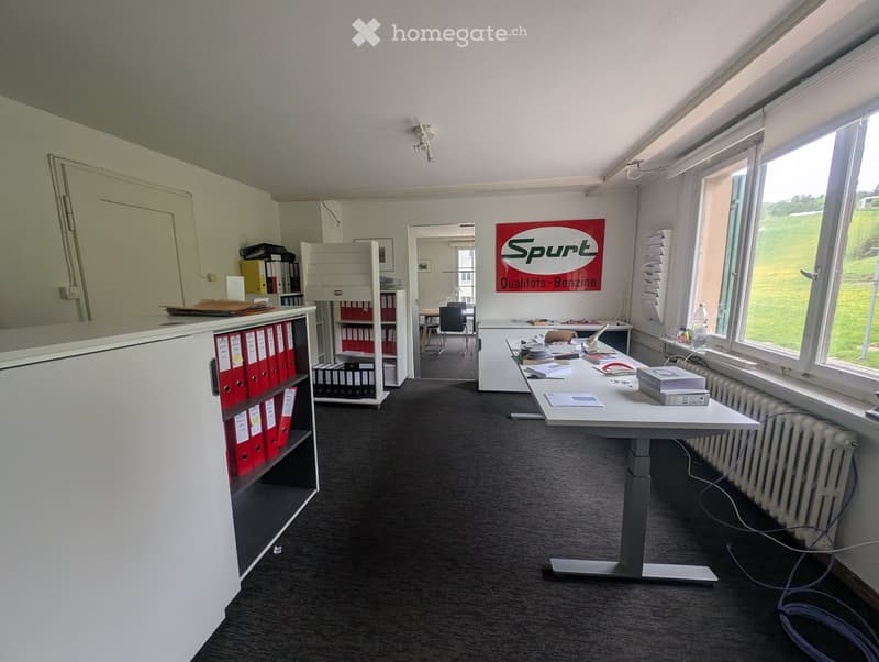 Office space with a large table, chairs, shelves with binders, and a radiator near the window.