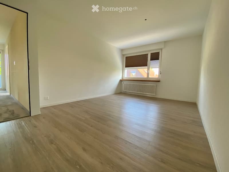Empty room with wooden flooring, white walls, and a window with blinds. No furniture or equipment present.