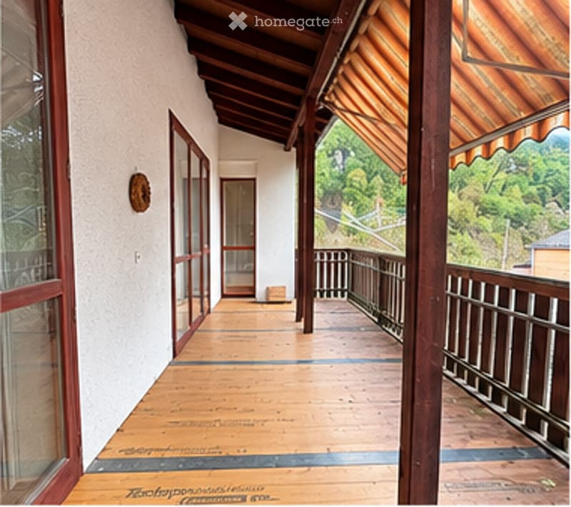 Wooden balcony with red-framed glass doors, wooden floor, metal railing, and a view of greenery.