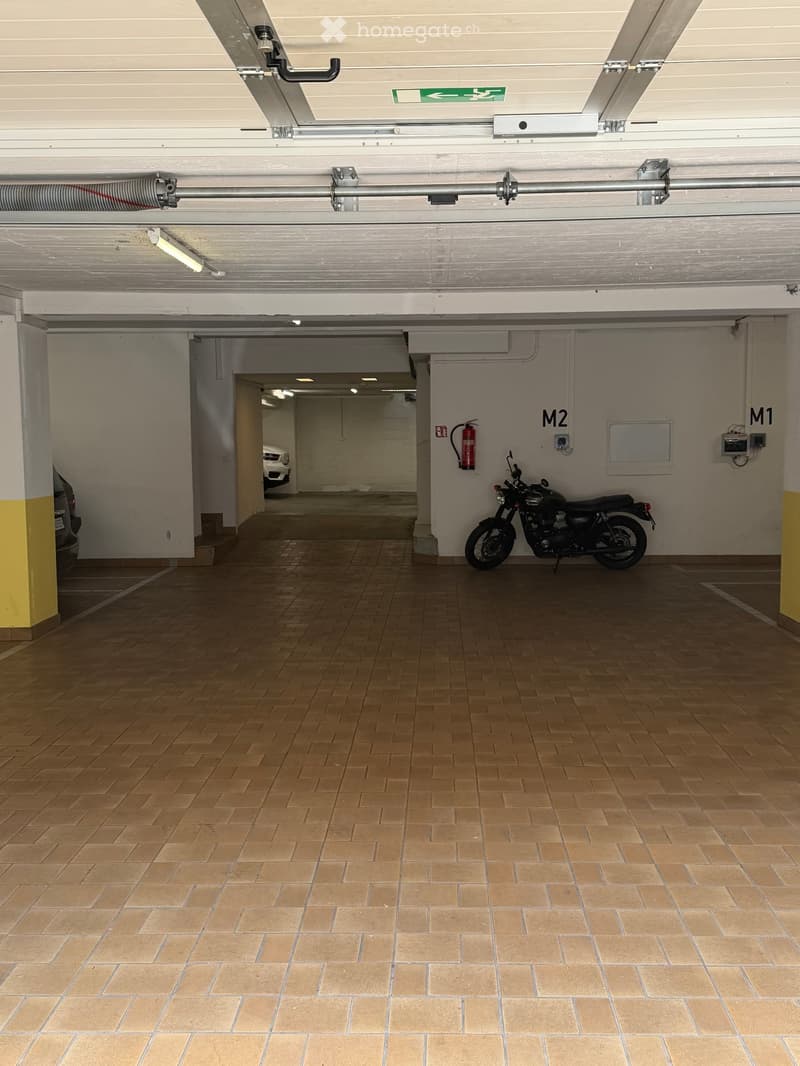 {"visible_features": ["Garage"], "type": "Garage", "objects": ["motorcycle"], "description": "Underground garage with tiled floor, motorcycle parked, fire extinguisher on wall, and access to another area.", "localized_descriptions": {"EN": "Underground ga