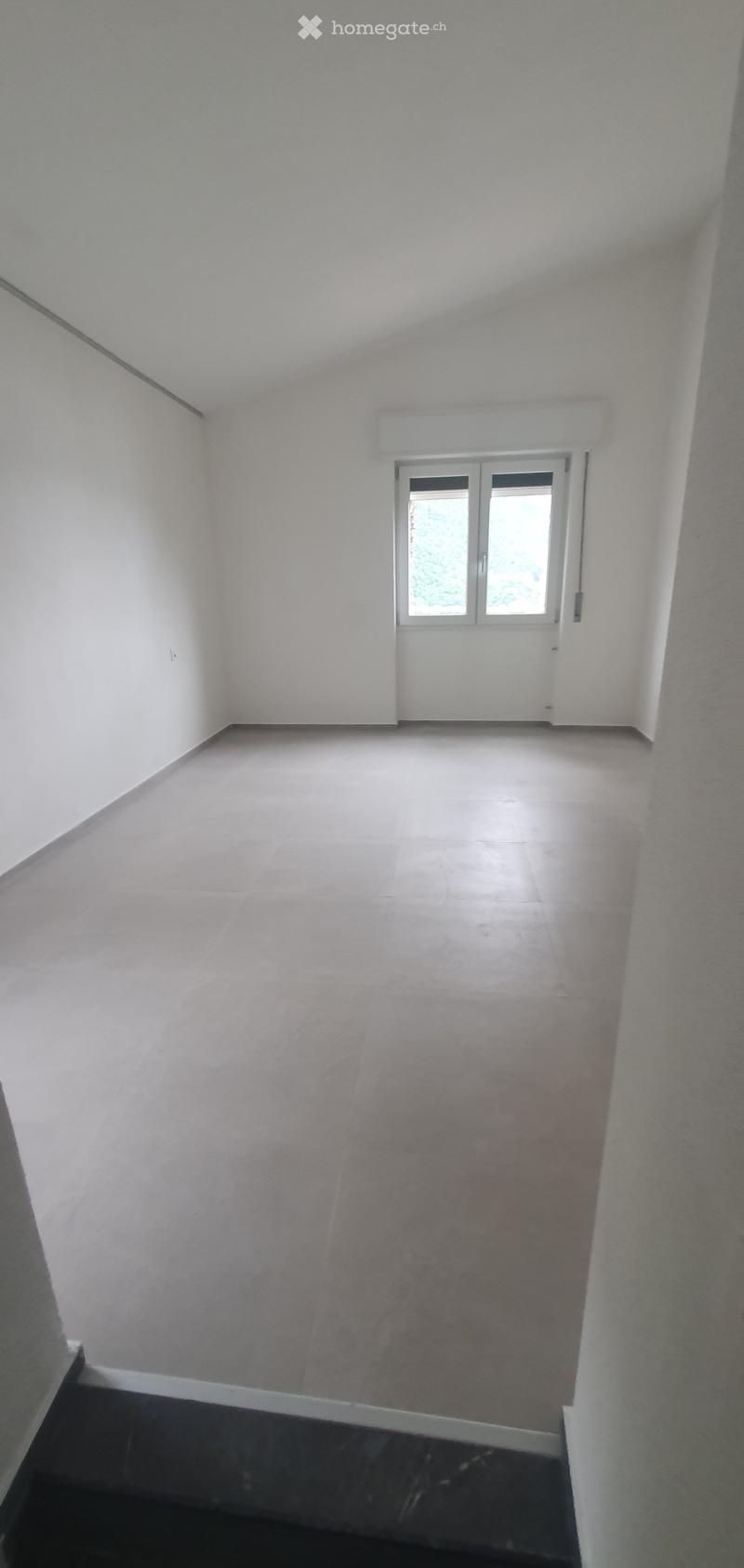 Unfurnished Room. Empty room with white walls, tiled floor, and a large window with white frame. No furniture or equipment present.