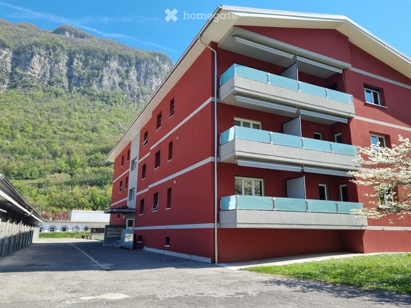 3 story building, red exterior, white trim, multiple balconies, mountain view