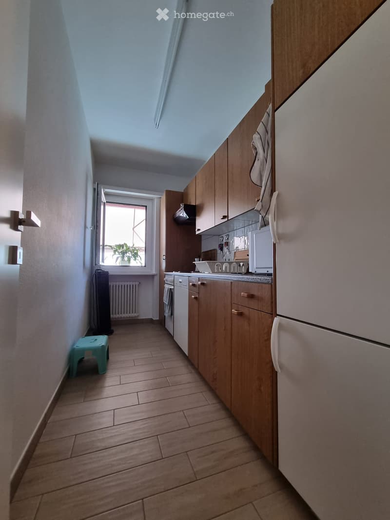 kitchen with wooden cabinets, white appliances, tiled floor, window with view, washing machine