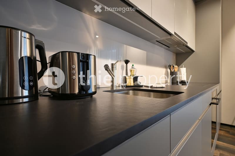 Modern kitchen, stainless steel appliances, granite countertop, white cabinets, silver faucet, tiled backsplash, gas stove, dishwasher, refrigerator, coffee maker