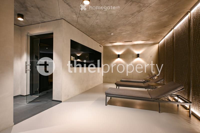 relaxation room, glass door, three lounge chairs, concrete and beige wall, ceiling lights