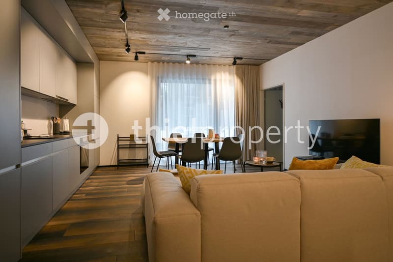 contemporary living room with wooden floors, white cabinets, dining table, couch, TV