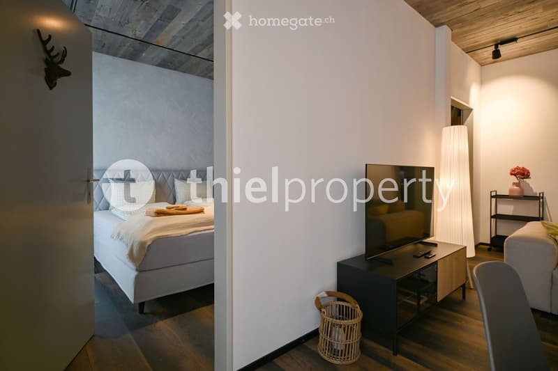 interior room with double bed, TV, remote control, small basket, decorative item on the wall