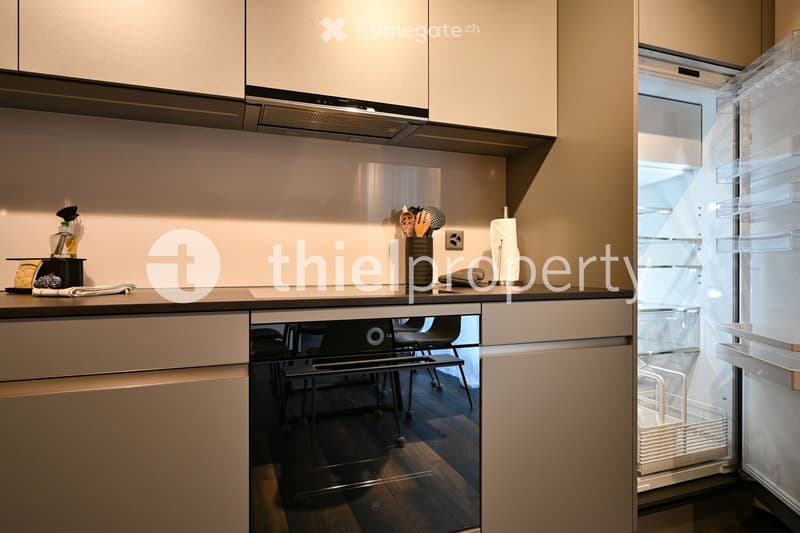 modern kitchen, white cabinets, wooden countertops, built-in oven, open refrigerator, dishwasher basket, utensils stand, wine bottle, teapot, towels, toaster, coffee maker