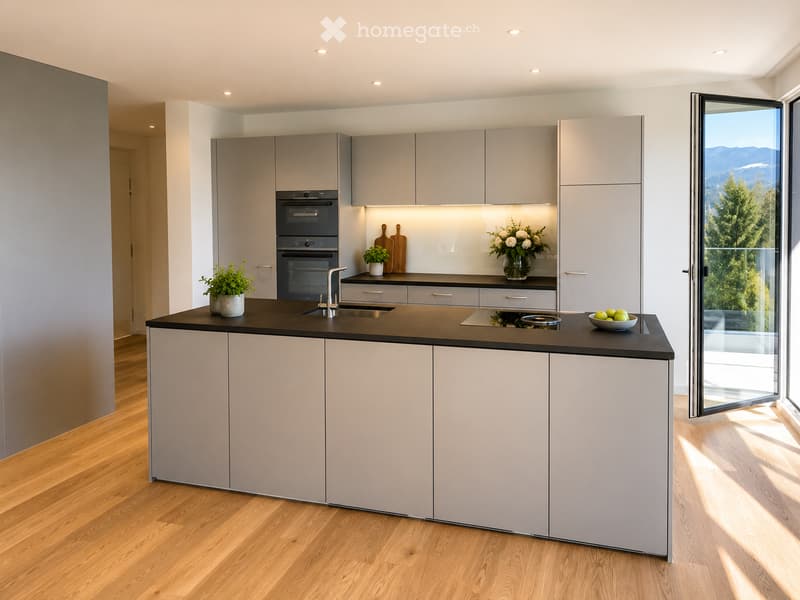 Modern kitchen with grey cabinets, black countertop, built-in oven, sink, and decorative items including a vase with flowers and a bowl of fruit.