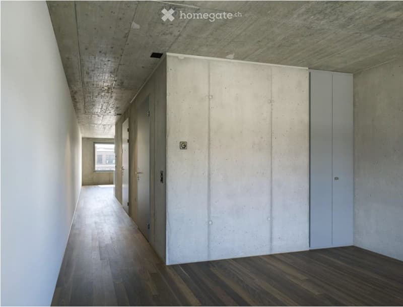 Empty hallway with wooden flooring, white walls, and closed doors on both sides.