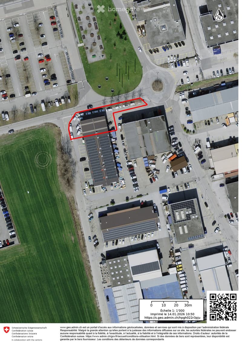 Aerial view of a commercial area with multiple buildings, parking lots, and solar panels on rooftops.