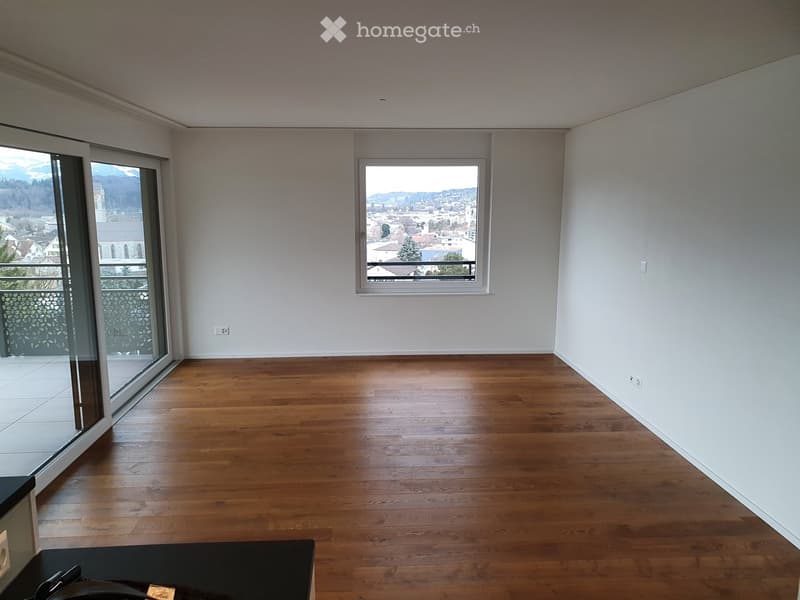 empty room, wooden floor, white walls, sliding glass doors, balcony, window with view