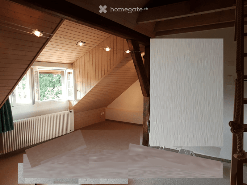 Empty attic room with wooden slanted ceilings, exposed wooden beams, large windows, and a radiator. No furniture or equipment present.