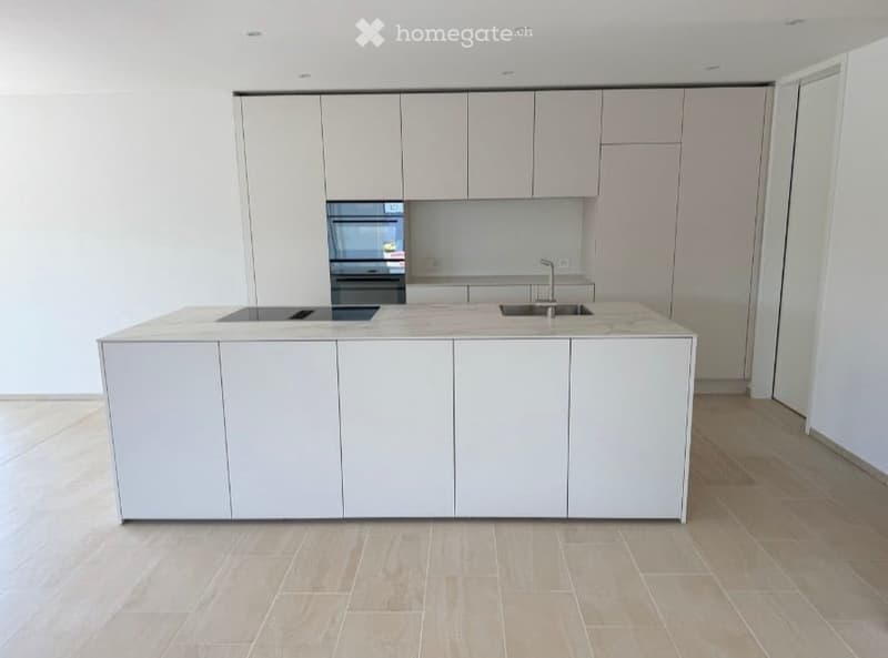 Modern kitchen with white cabinets, a central island, an oven, and a sink.