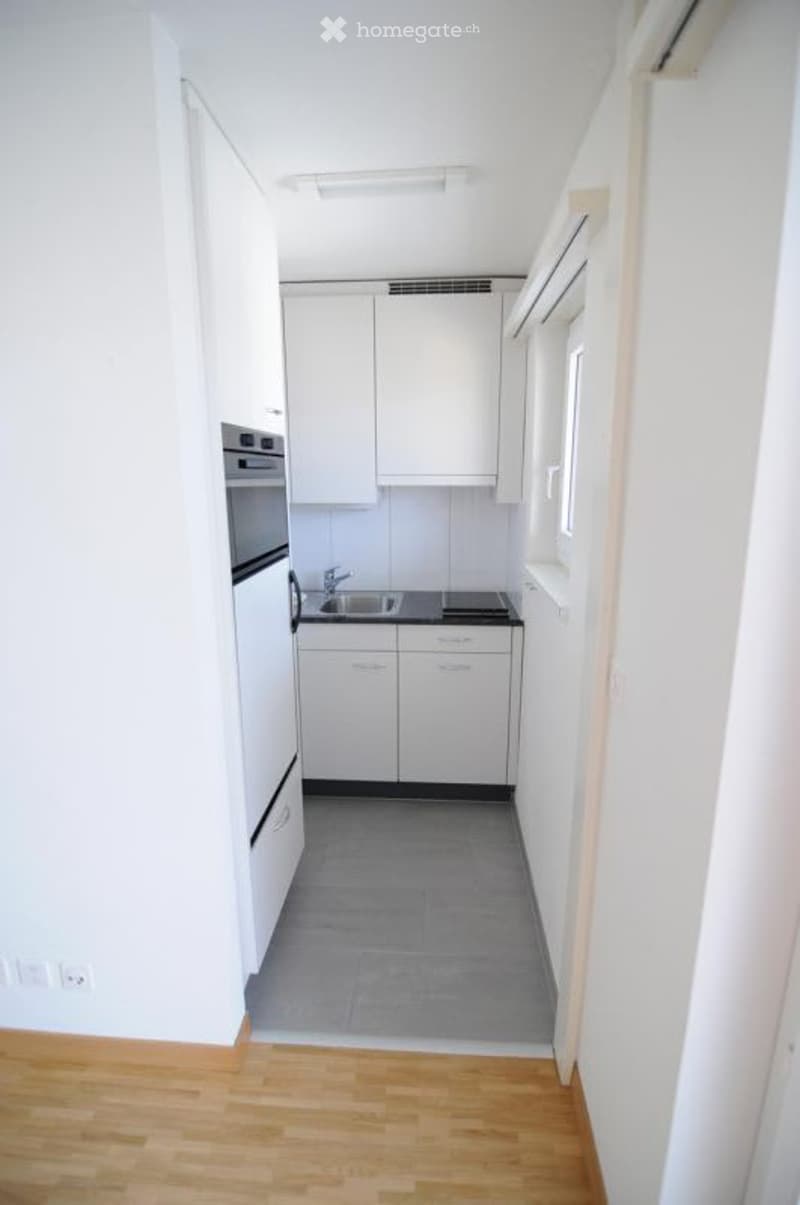 Modern white kitchen, gas stove, stainless steel sink, tile floor