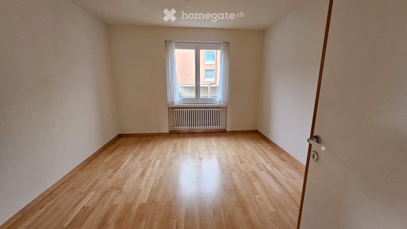 empty room, wooden floor, white walls, window with white curtains, white radiator