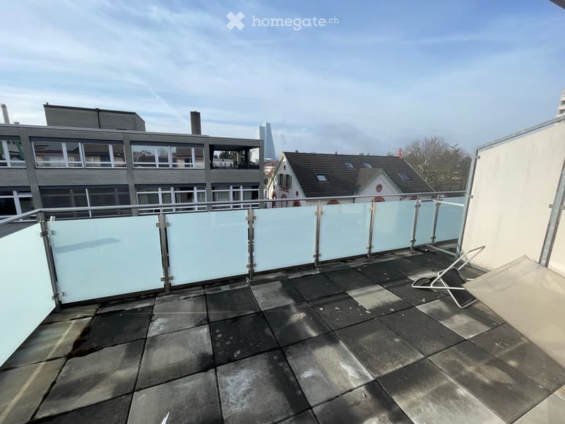 Roof terrace with tiled floor, glass railing, and a single lounge chair.