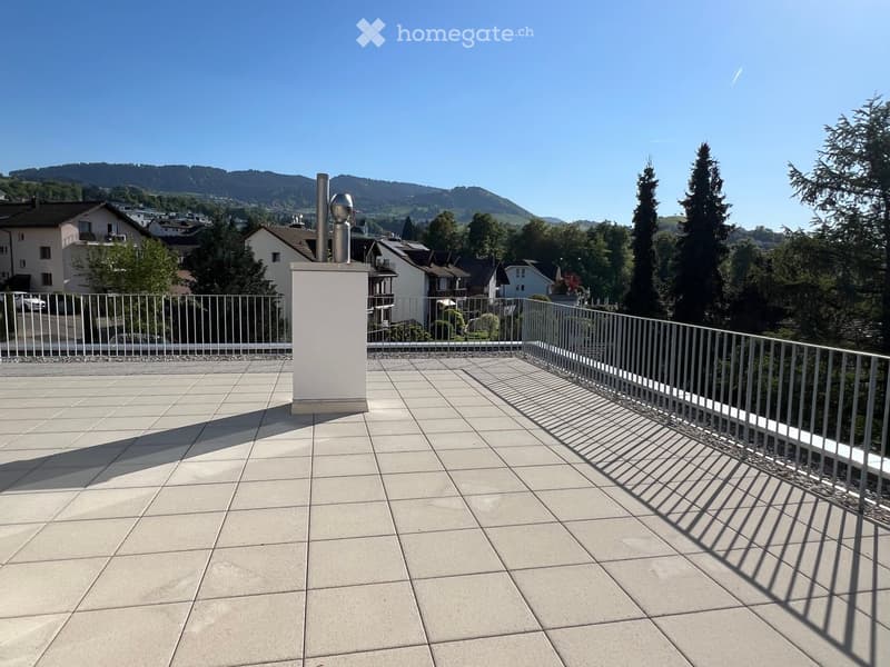 Roof terrace with tiled flooring, metal railing, and scenic mountain view in the background.