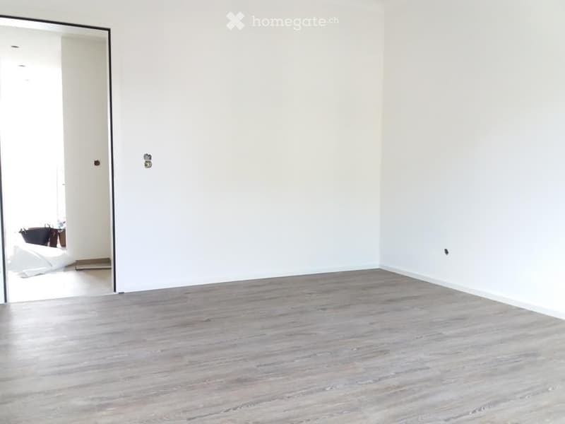 Empty room with light grey wooden flooring and white walls. No furniture or equipment visible.