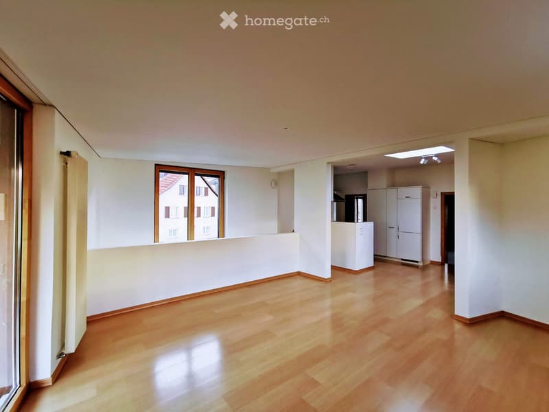 Empty room with wooden flooring, white walls, and large windows. No furniture or equipment present.