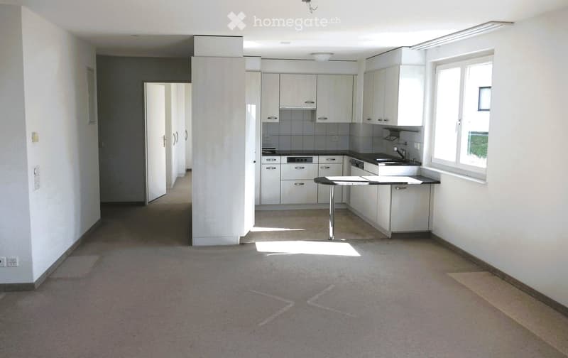 Empty kitchen with white cabinets, countertops, sink, and appliances.