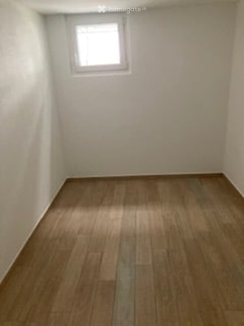 Completely empty room with bare white walls and wooden floor. No furniture or equipment.