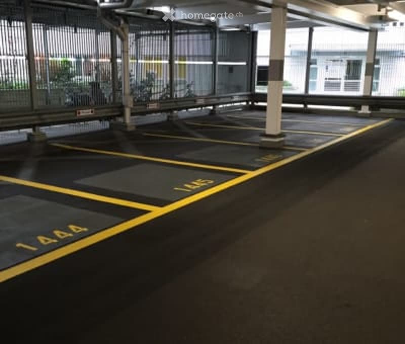 Empty parking lot with number markings and fences on either side