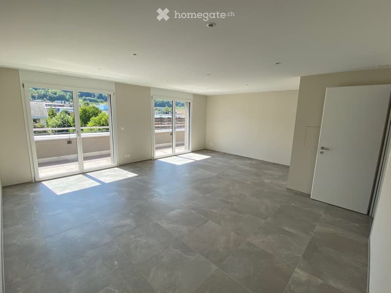 Empty room with large sliding glass doors leading to a balcony, tiled floor, and neutral-colored walls.